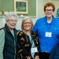 Four alumnae pose for a photo together at the Reunion Dinner.